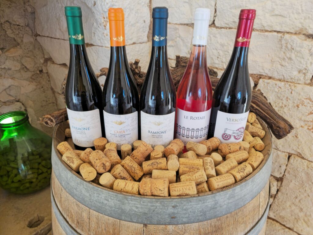 Assorted red wine bottles and corks on a rustic table