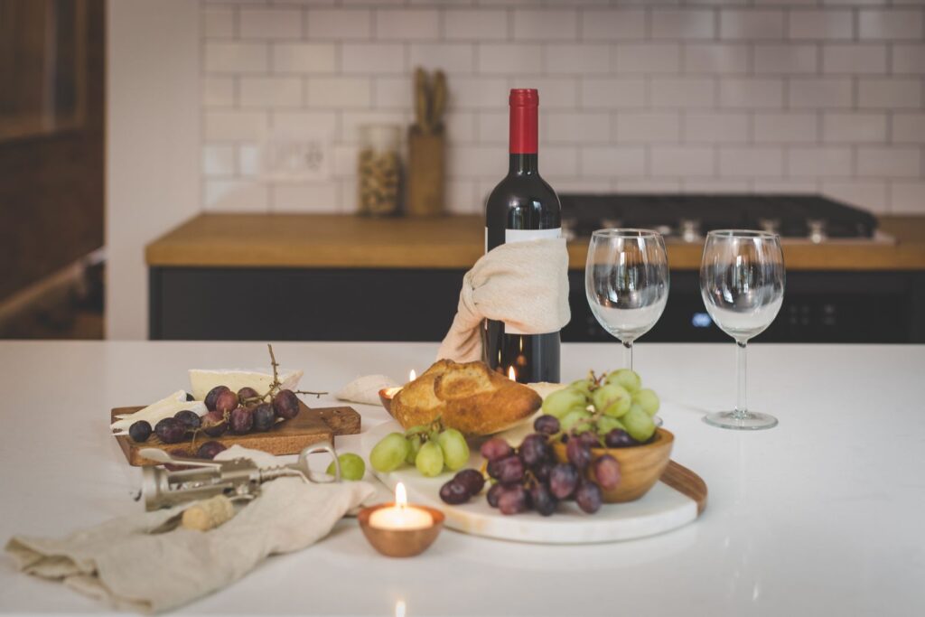 Assorted cheeses on a wooden board with glasses of red and white wine